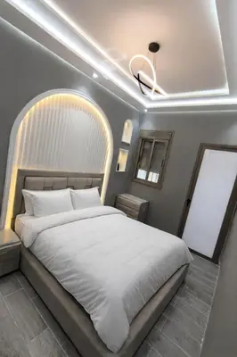 a bedroom with a large white bed with a ceiling at Haut standing apartment in hearth of fez in Fès