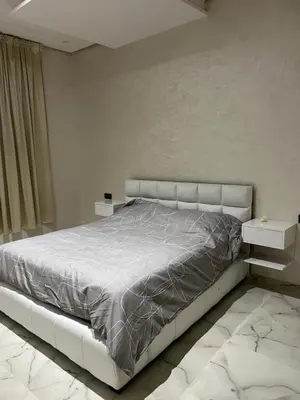 a bedroom with a large bed with a white headboard at Haut standing apartment in hearth of fez in Fès