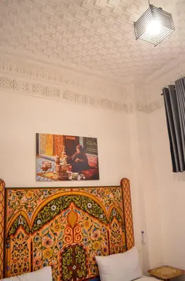 a bedroom with a bed and a painting on the wall at Dar al mardi fes luxury in Fès