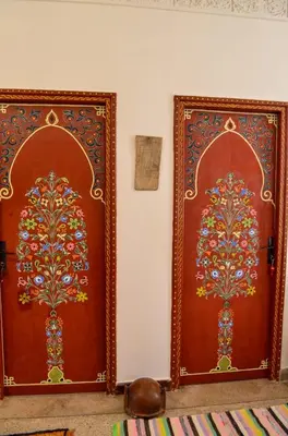 two wooden doors with floral designs on them at Dar al mardi fes luxury in Fès