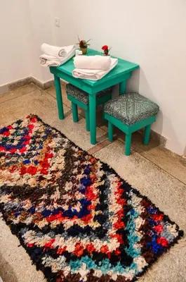 a green table and a stool next to a rug at Dar al mardi fes luxury in Fès