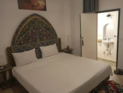 a bedroom with a bed with a headboard and a sink at Dar al mardi fes luxury in Fès