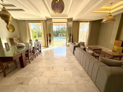 a living room with a couch and a table and chairs at Luxury Villa with Private XXL Pool in Azib Oulad Lâdem