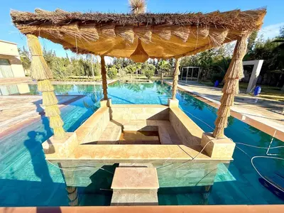 a swimming pool with a gazebo in the middle at Luxury Villa with Private XXL Pool in Azib Oulad Lâdem