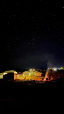 a parking lot at night with lights on at Desert Halo Camp in Merzouga
