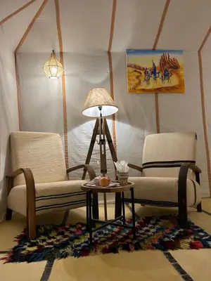 a living room with two chairs and a table at Desert Halo Camp in Merzouga