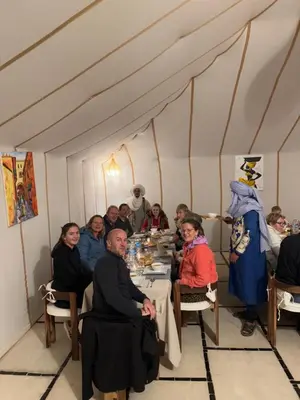 a group of people sitting at a table in a room at Desert Halo Camp in Merzouga