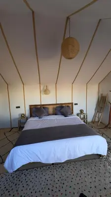 a bedroom with a large bed in a room at Desert Halo Camp in Merzouga