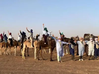 a group of people riding on the backs of horses at merzouga best luxury camp in Merzouga