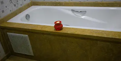 a bath tub with a red bottle sitting in it at Nise Apartment in Oulad Akkou