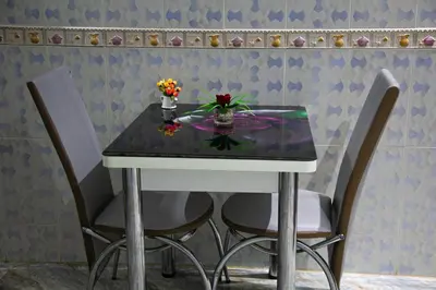 a table with two chairs and a table with flowers on it at Nise Apartment in Oulad Akkou