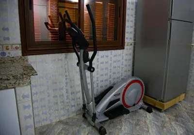 a vacuum in the corner of a kitchen next to a refrigerator at Nise Apartment in Oulad Akkou