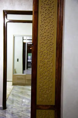 a wooden door with a mirror in a room at Nise Apartment in Oulad Akkou