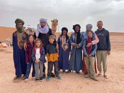 a group of people posing for a picture in the desert at M'hamid El Ghizlane, Provinz Zagora in Oulad Akkou