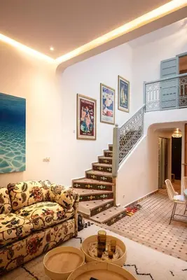 a living room with a staircase and a couch at Riad Tiklit in Oulad Akkou