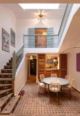 a room with a table and chairs and stairs at Riad Tiklit in Oulad Akkou
