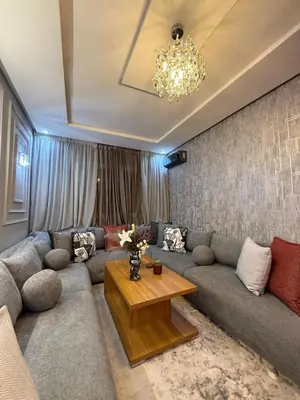 a living room with a couch and a table at modern family stay in Meknès