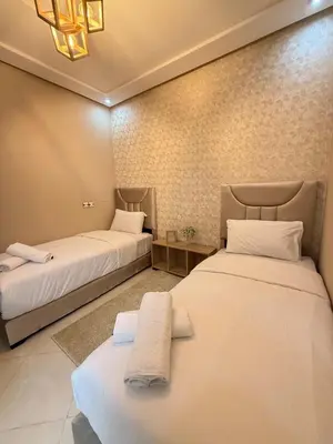 two beds in a room with white sheets at modern family stay in Meknès