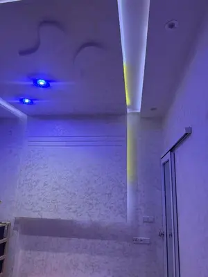 a room with a white wall and a ceiling with blue lights at Appartement Fès standing in Fès