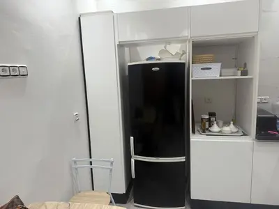 a black refrigerator in a white cabinet in a room at Appartement Fès standing in Fès