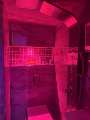a bathroom with a pink lighted shower with a toilet at Appartement Fès standing in Fès