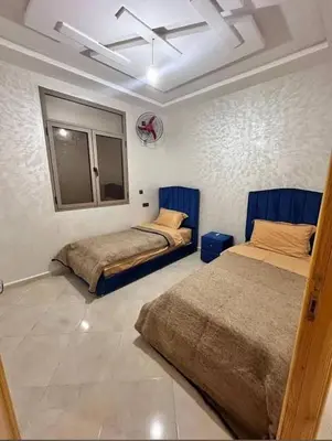 a bedroom with two beds and a basketball hoop at merzouga apartment in Merzouga
