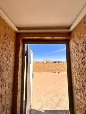 a door to a room with a view of a field at merzouga apartment in Merzouga