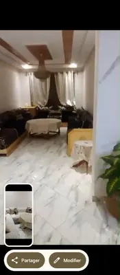a living room with a white tiled floor at Amir's home in Meknès