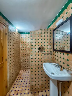 a bathroom with a sink and a mirror at Riad Les Émeraudes De Fes in Fès