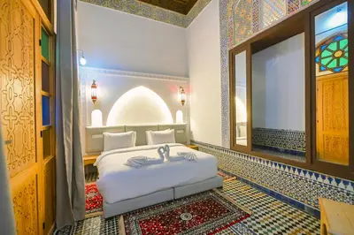 a bedroom with a bed in a room with a window at Riad Les Émeraudes De Fes in Fès
