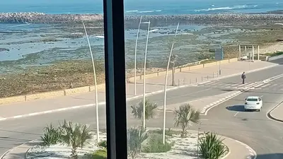 a view from a window of a street with a car at Appartement avec vue panoramique sur la mer, climatisation, terrasse & ascenseur in Oulad Akkou