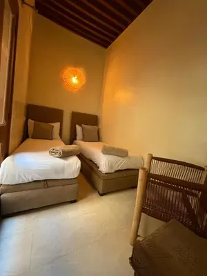 a bedroom with two beds and a couch in it at Dar Al Rcif in Station Bab Ftouh