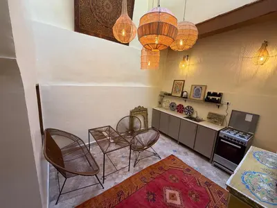 a living room with chairs and a table and a counter at Dar Al Rcif in Station Bab Ftouh