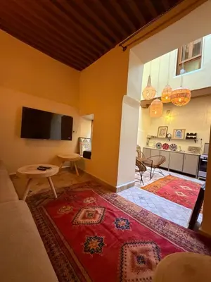 a living room with a television and a rug at Dar Al Rcif in Station Bab Ftouh