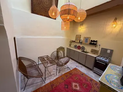 a living room with chairs and a table and a counter at Dar Al Rcif in Station Bab Ftouh