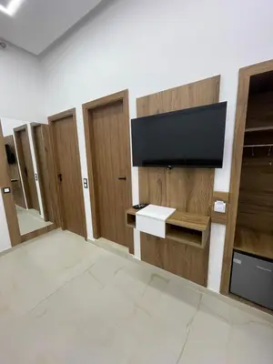 a room with wooden doors and a flat screen tv at Hotel kairouan in Fès