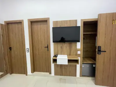 a room with three wooden doors with a television at Hotel kairouan in Fès