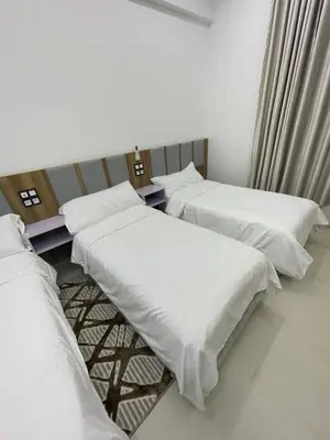 three beds in a room with white sheets at Hotel kairouan in Fès