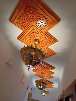 a coffered ceiling with chandeliers hanging from it at Dar AWRABIA in Fès