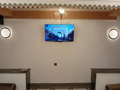 a room with a flat screen tv on the wall at Dar AWRABIA in Fès