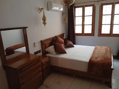 a bedroom with a large bed and a mirror at Dar AWRABIA in Fès