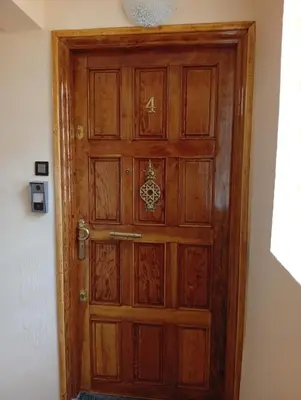a wooden door in the corner of a room at Dar AWRABIA in Fès