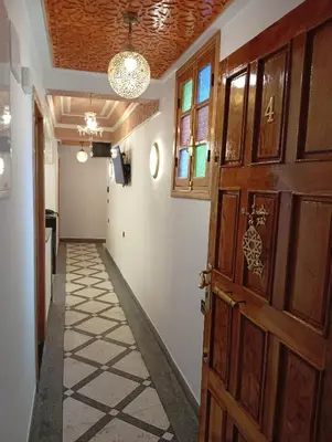 a hallway with a wooden door and a room at Dar AWRABIA in Fès