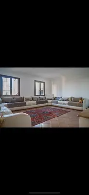 a large room with couches and a rug at Appartement très spacieux au coeur de Temara à 10 minutes du grand stade de Rabat in Oulad Akkou