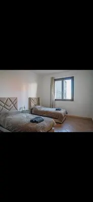 a bedroom with two beds and a window at Appartement très spacieux au coeur de Temara à 10 minutes du grand stade de Rabat in Oulad Akkou