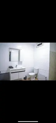 a white bathroom with a sink and a toilet at Appartement très spacieux au coeur de Temara à 10 minutes du grand stade de Rabat in Oulad Akkou