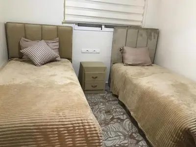 two beds sitting next to each other in a bedroom at Central, modern and well-equipped apartment in Oulad Akkou