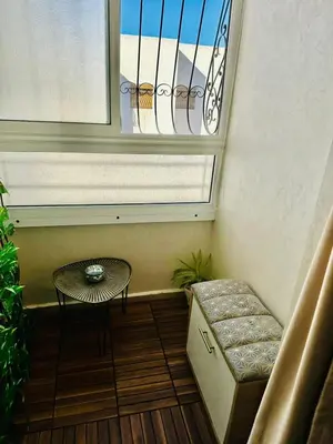 a small balcony with a table and a window at Central, modern and well-equipped apartment in Oulad Akkou