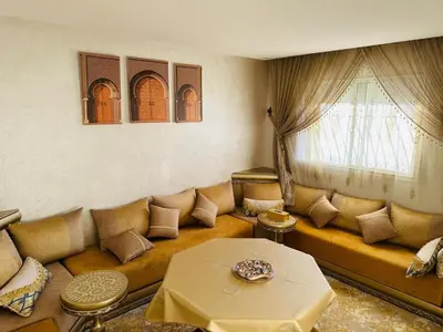 a living room with a couch and a table at Central, modern and well-equipped apartment in Oulad Akkou