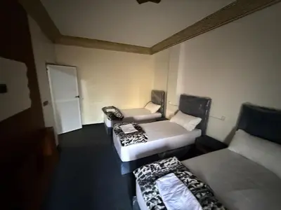 a small room with two beds and a door at Fes Apartment 2 in Fès